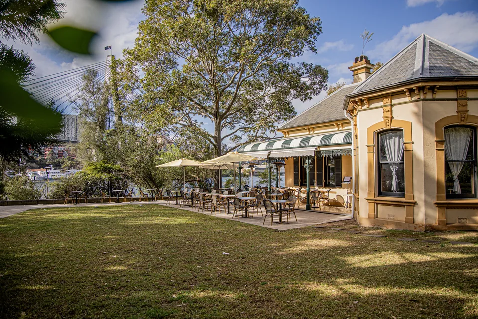 Bellevue Cottage and its outdoor dining terrace beside the lawn in Glebe.