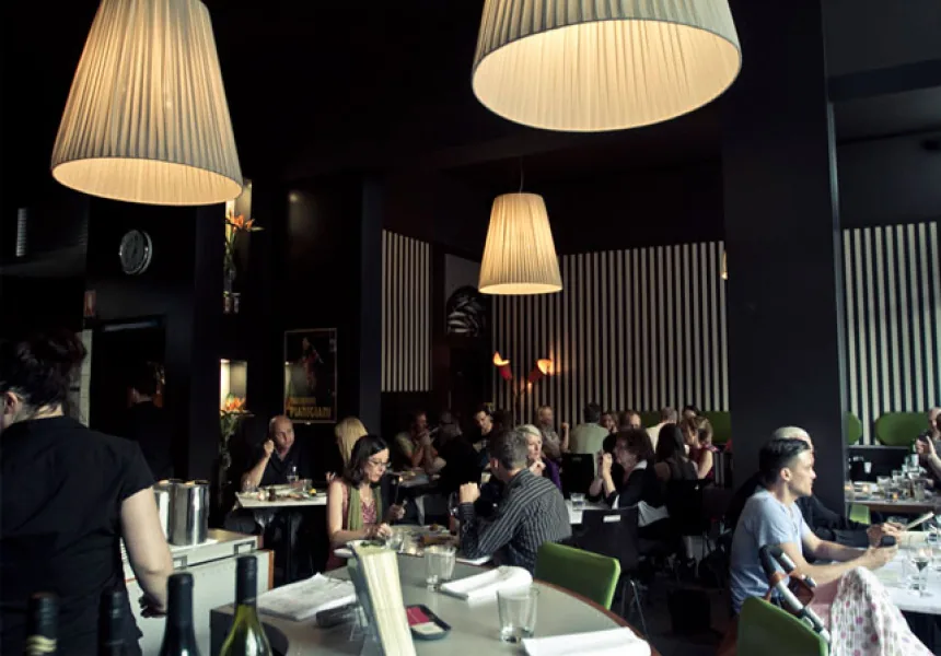 Diners beneath pendant lamps in the striped dining room at Glebe Point Diner.