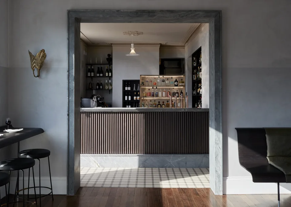 View through the pale blue dining room to the ribbed bar counter at No92 in Glebe.