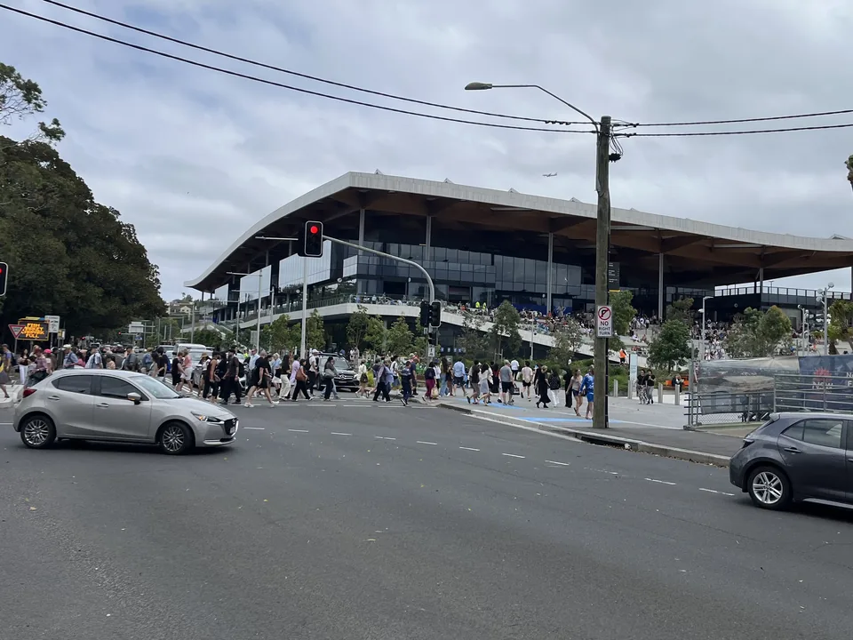 Visitors outside the new Sydney Fish Market on Bridge Road, beneath its broad wave-shaped roof.