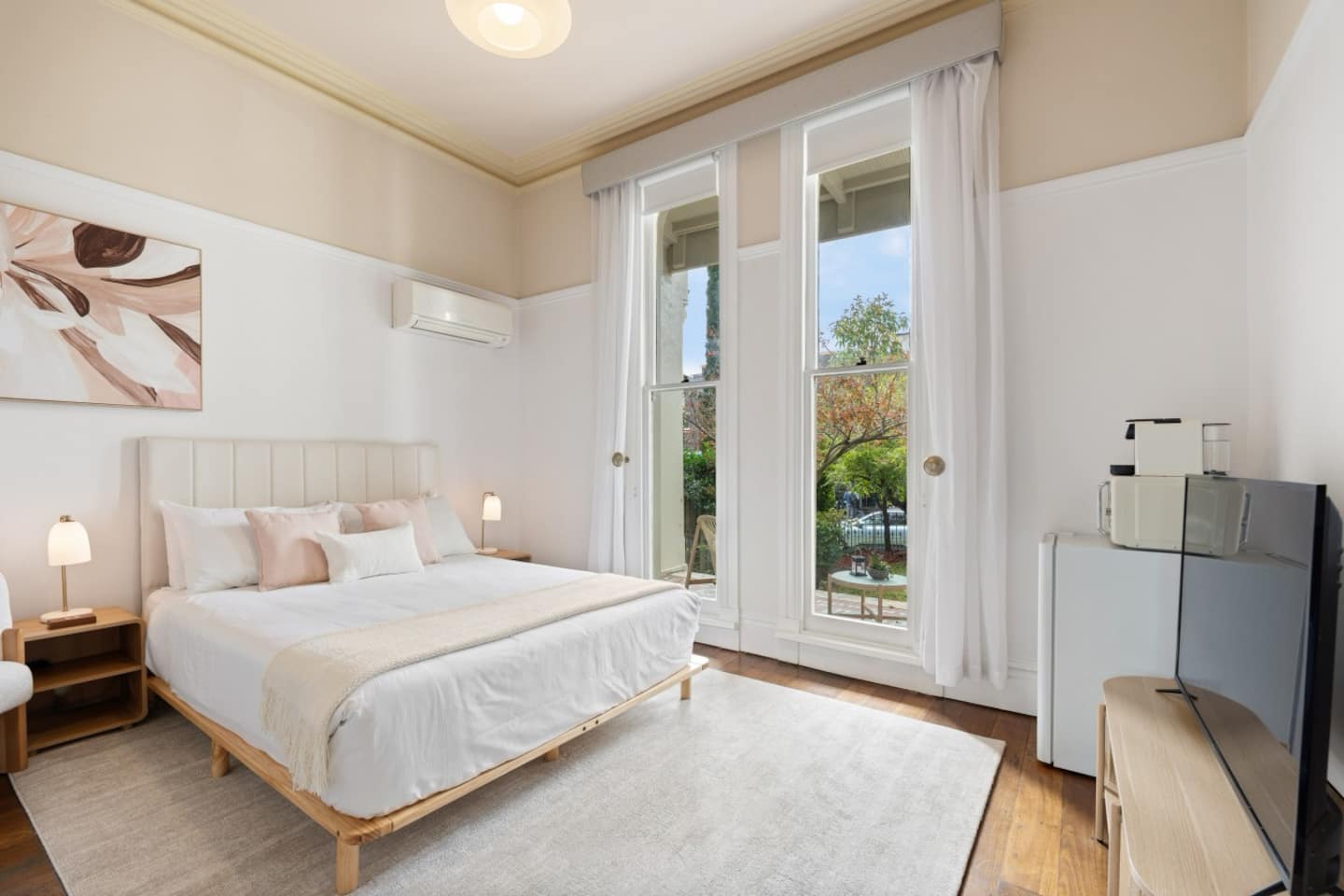 The Magnolia Room with the bed, magnolia artwork and ceiling-to-floor double sash windows